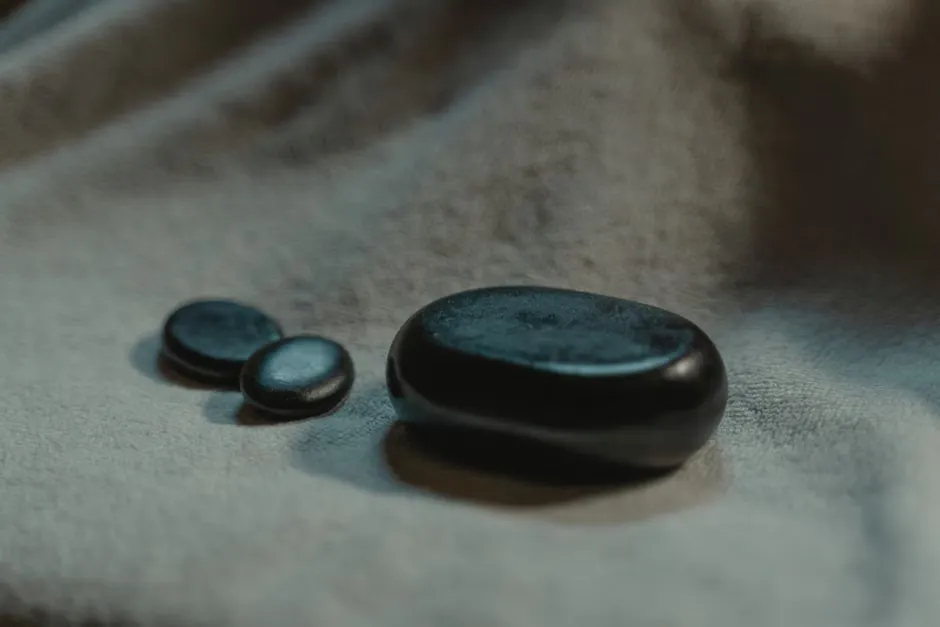 Smooth pebbles in soft pastel tones arranged on pale sand