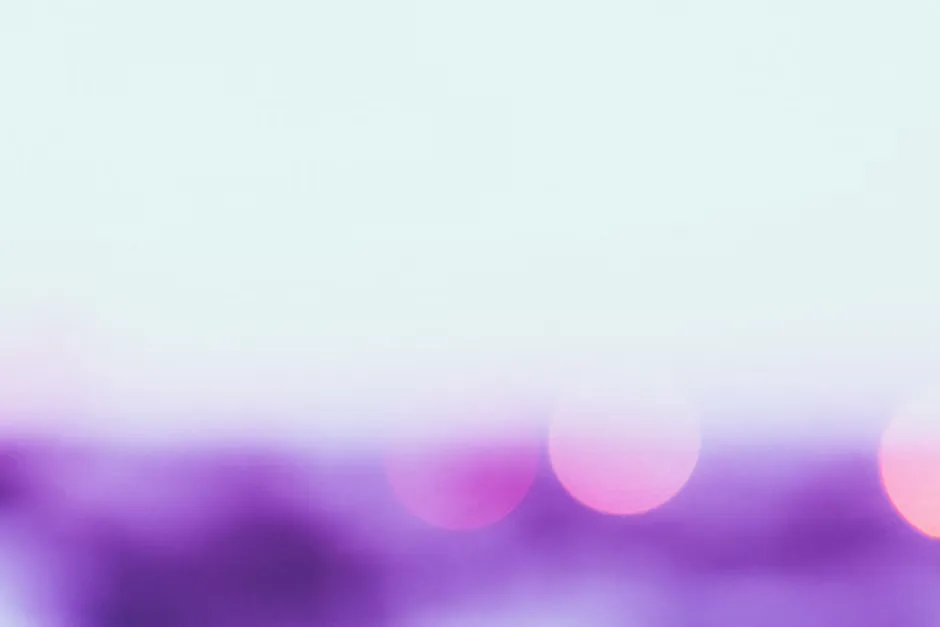 Soft violet light falling across folded linen sheets and an open notebook on a bedside table